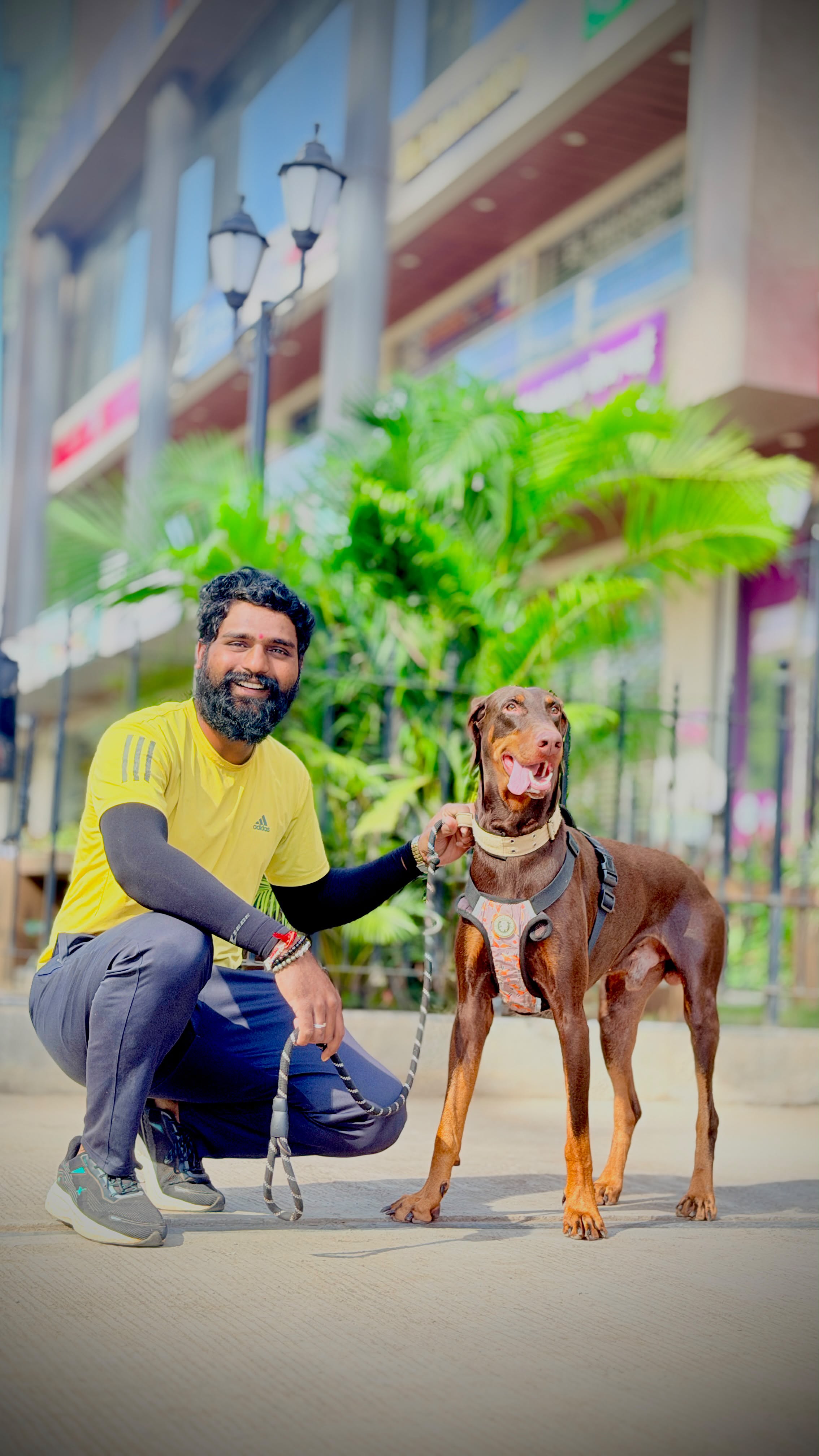 Walker crouched beside a Doberman on a Kharadi street
